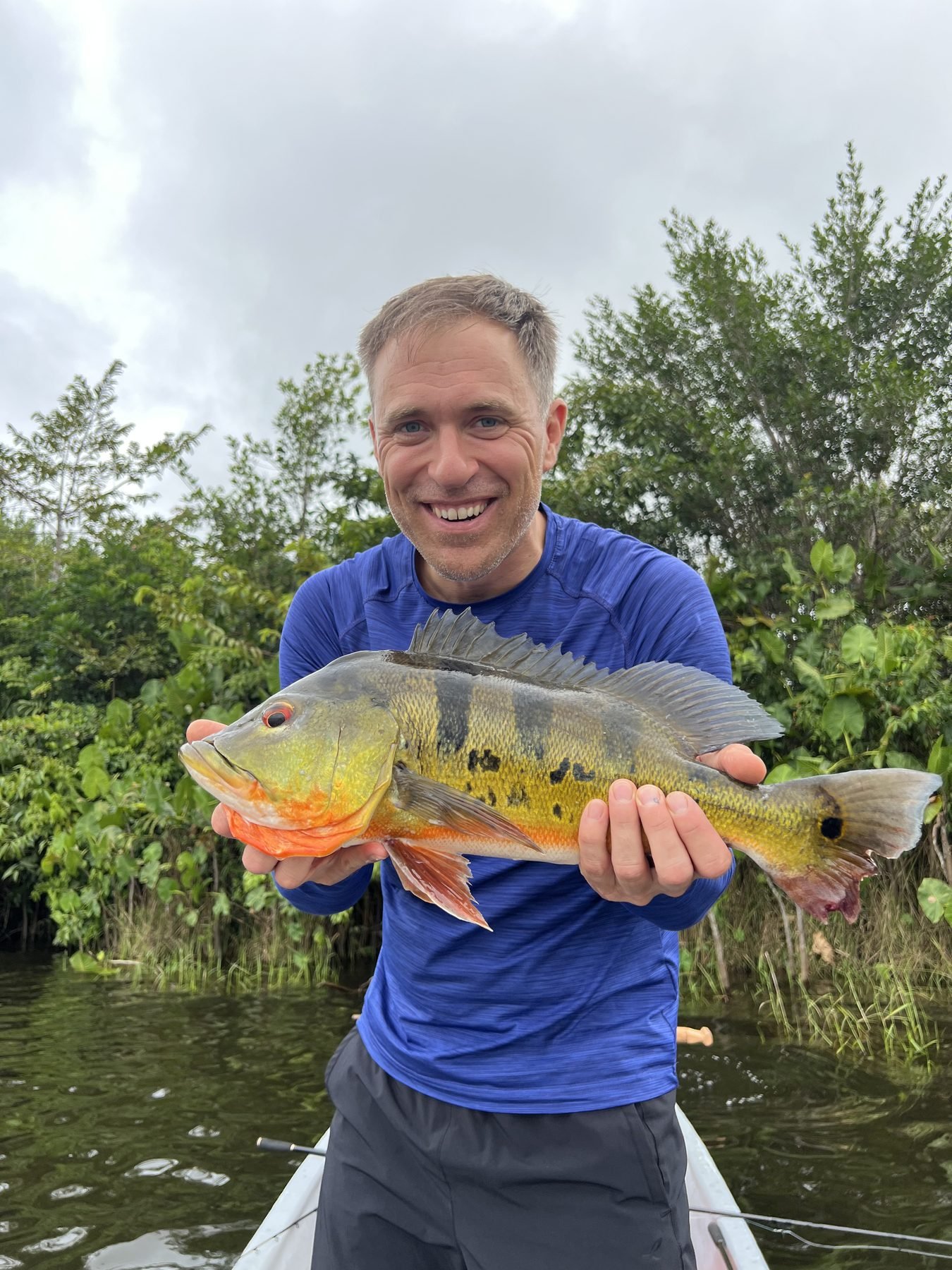 Smiling angler with a peacock bass