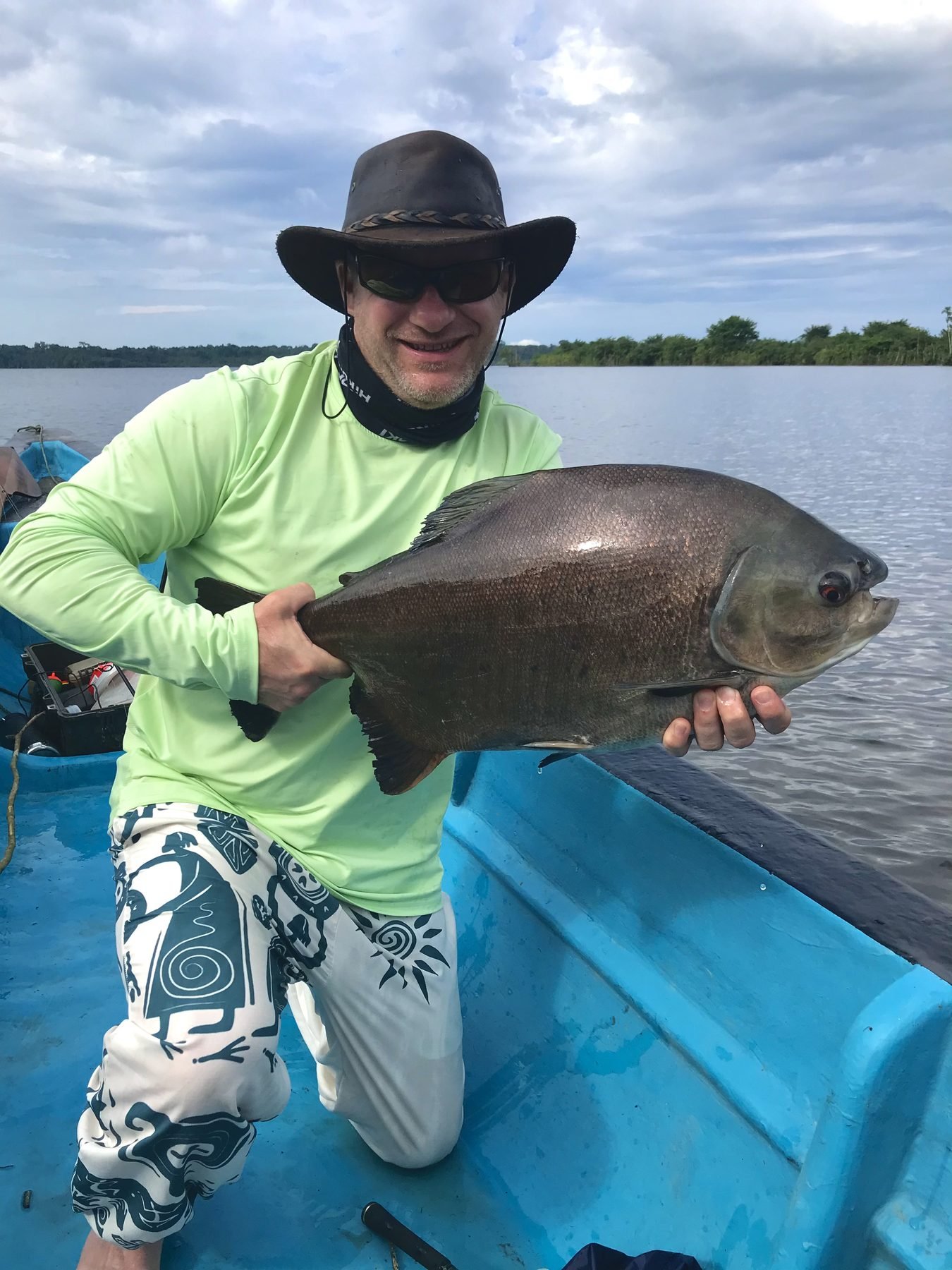 Angler with a pacu in the fishing canoe