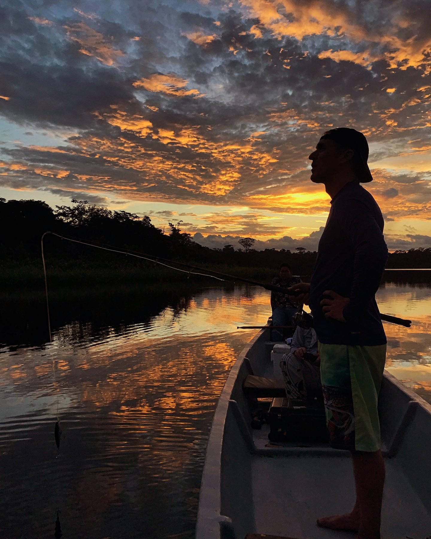 Angler silhouetted against an Amazon sunset
